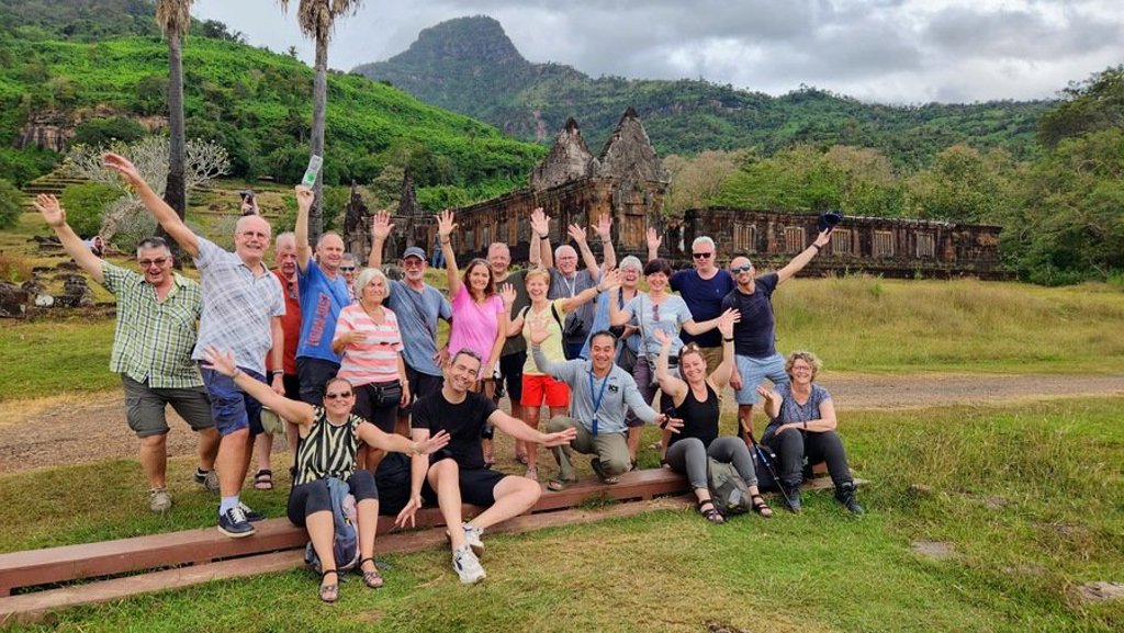 Monniken lopen langs een tempelcomplex tijdens een groepsrondreis door Laos en Cambodja.