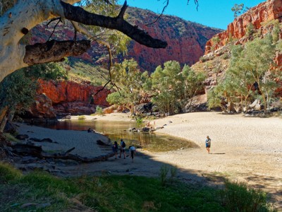 Zandstrand langs een rivier in een rode rotskloof bij Simpsons Gap, West MacDonnell Ranges, Australië.