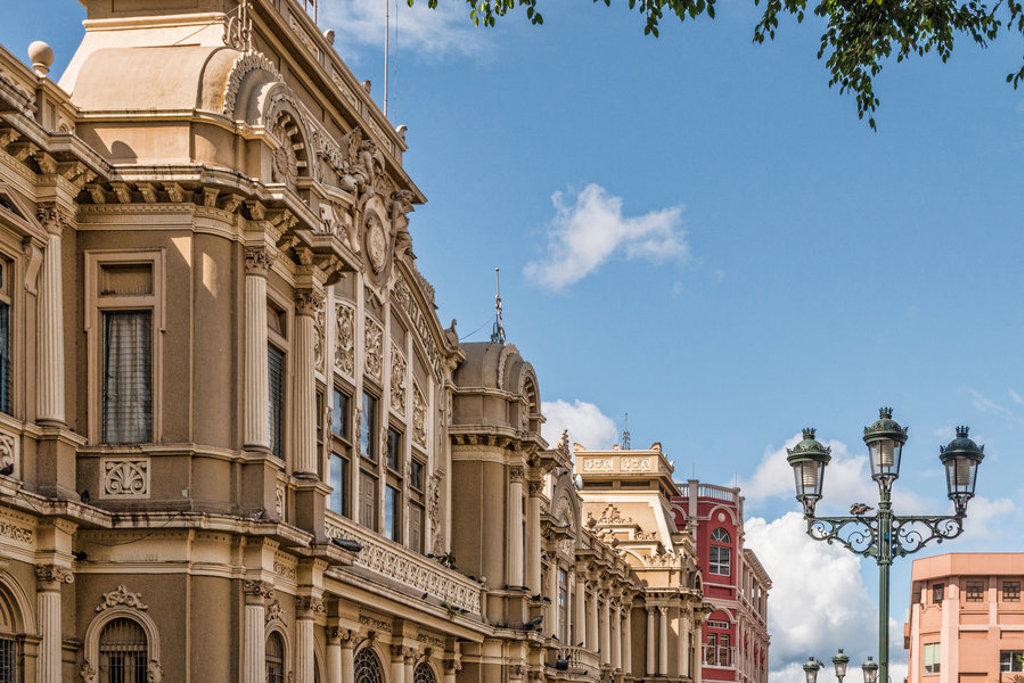 Historische gevels in het centrum van San José, Costa Rica, met straatlantaarns en blauwe lucht.