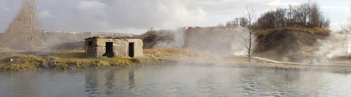 Stoom boven het warme water van Secret Lagoon, een natuurlijke warmwaterbron in IJsland.