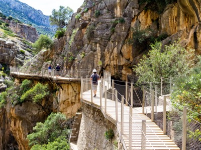 Wandelaars op houten wandelpad langs steile rotswand in de Caminito del Rey-kloof, Andalusië, Spanje.