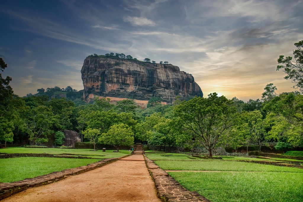 Sigiriya-rots met pad door groen landschap tijdens groepsrondreis Sri Lanka.