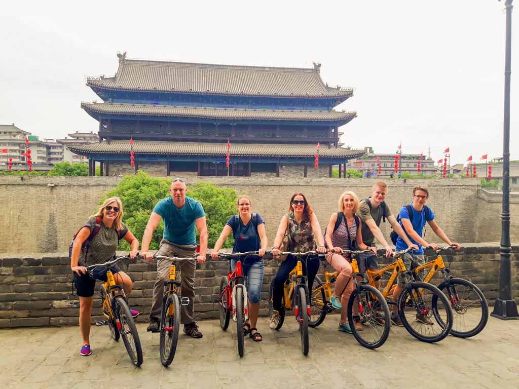 Gezin op de fiets bij de stadsmuur en de Drum Tower in Xi’an tijdens een familiereis China.