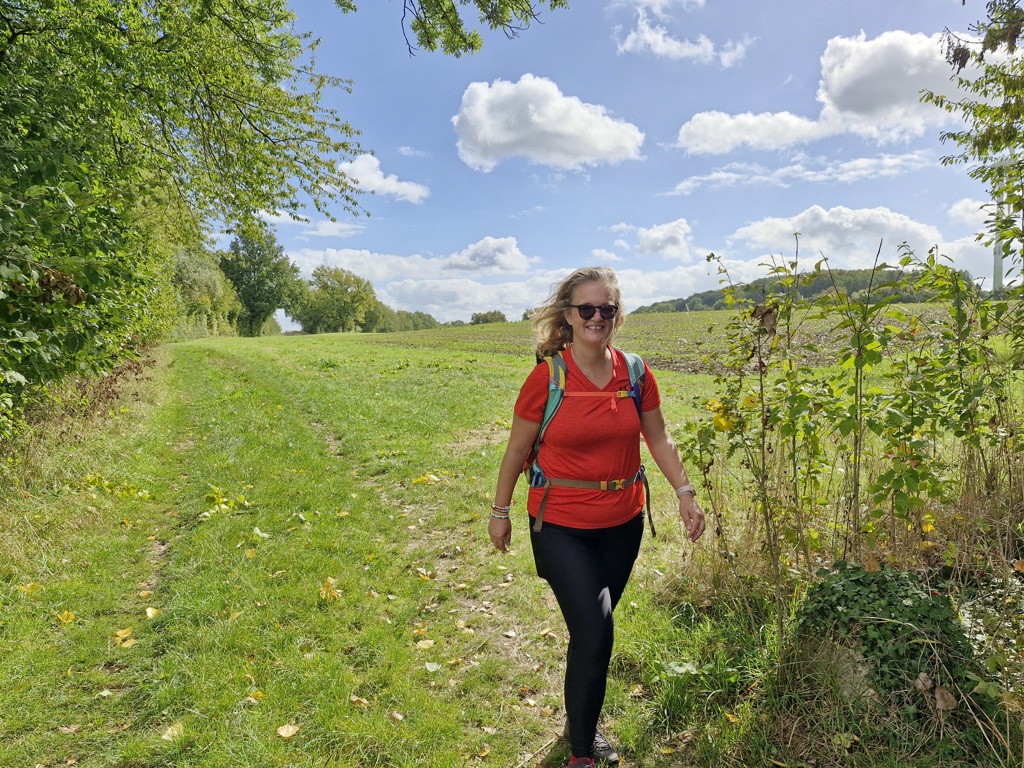 Wandelaar op een groen pad door het Limburgse heuvelland tijdens de Dutch Mountain Trail-wandelvakantie.