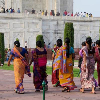Bezoekers in kleurrijke sari’s lopen langs de Taj Mahal in Agra tijdens een groepsrondreis Noord-India.