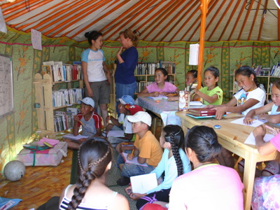 Les in een Mongoolse ger met kinderen die schrijven en lezen in een kleine bibliotheek.
