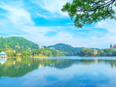 Uitzicht over het Kandy-meer met groene heuvels en reflectie in het water, Sri Lanka.