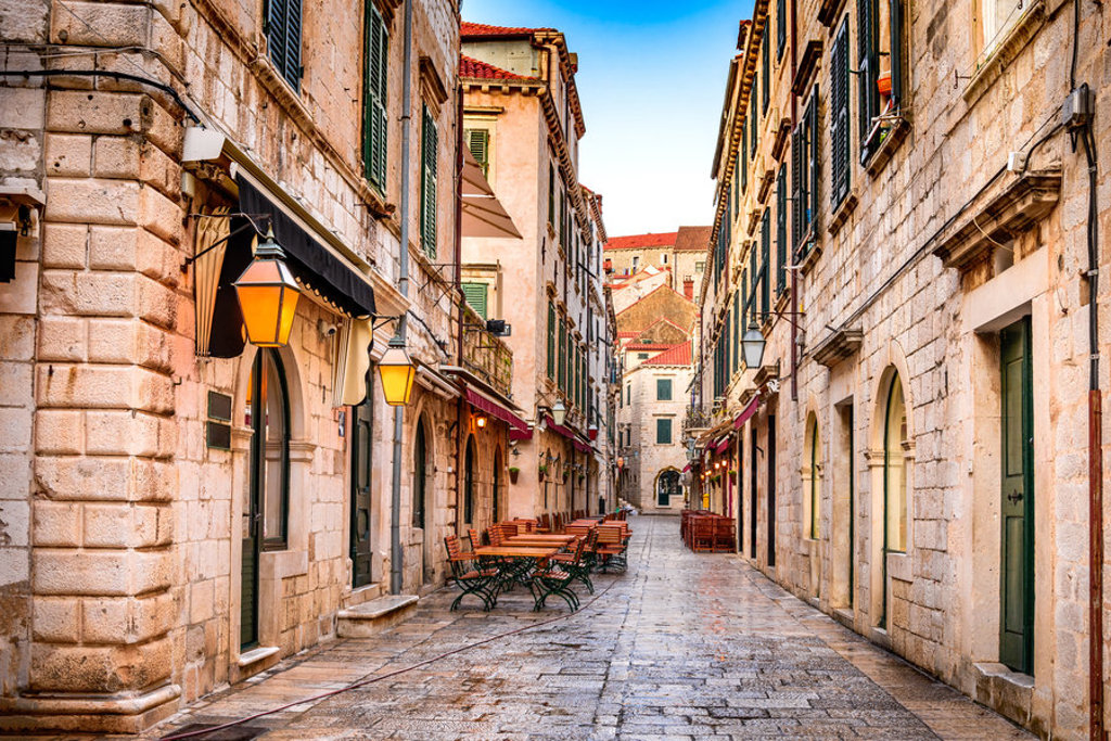 Sfeervolle oude straat met stenen huizen en terrasjes tijdens een groepsrondreis Balkan.