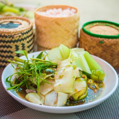 Laotiaans gerecht met verse groenten en kleefrijst, geserveerd bij een Laotiaanse kookles met lunch of diner.