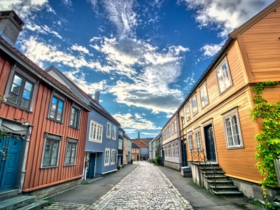 Gekleurde houten huizen langs een geplaveide straat in Trondheim, Noorwegen.