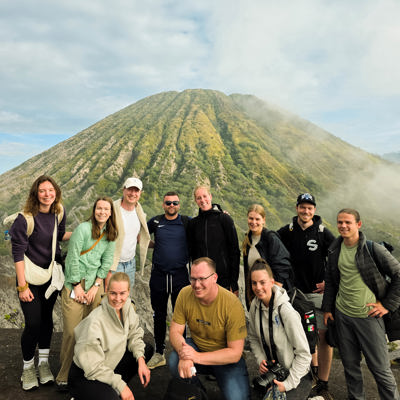 Groep 22-35ers tijdens rondreis Java en Bali met uitzicht op een vulkaan in Indonesië.
