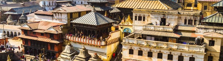 Pashupatinath-tempelcomplex in Kathmandu met pagodedaken en drukke trappen langs de Bagmati-rivier.
