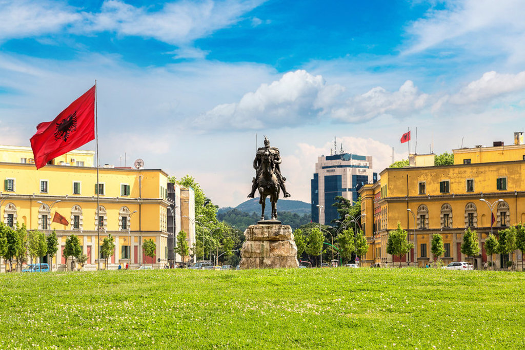 Standbeeld van Skanderbeg op het Skanderbegplein in Tirana, Albanië, met Albanese vlaggen.