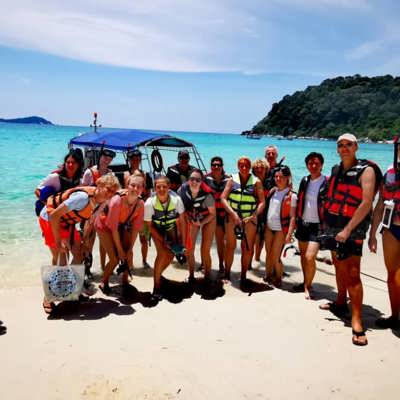 Tropisch strand met palmbomen en rotsachtige kust in Maleisië tijdens een familiereis.