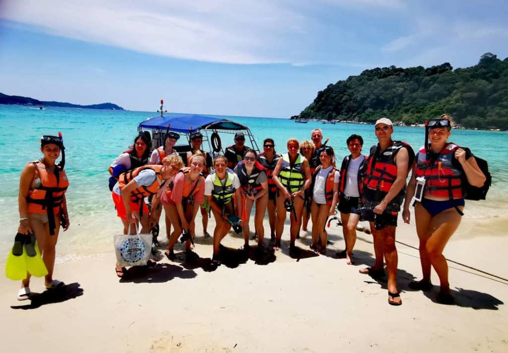 Tropisch strand met palmbomen en rotsachtige kust in Maleisië tijdens een familiereis.