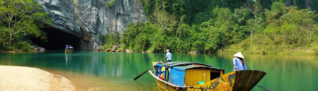 Boottocht op de Son-rivier bij Phong Nha, Vietnam, langs groene karstbergen en grotten.