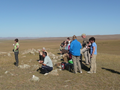 Reizigers genieten van een pauze met thee op de Mongoolse steppe tijdens de 23-daagse route door Mongolië.
