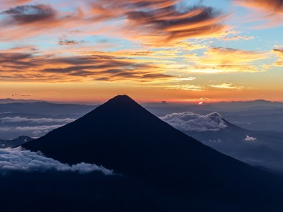 Zonsopkomst boven de vulkaan Acatenango in Guatemala, met wolkenzee en kleurrijke lucht.