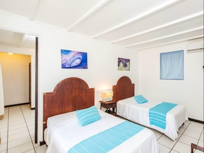 Slaapkamer met twee eenpersoonsbedden in Pueblo Dorado, met blauw beddengoed en nachtkastje.