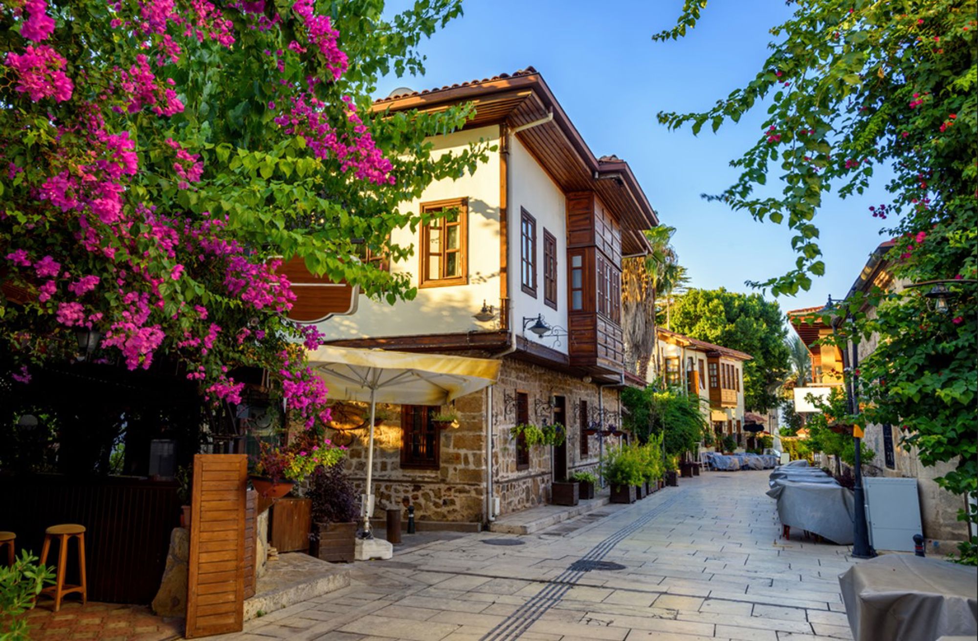 Traditionele Ottomaanse huizen in de oude binnenstad van Antalya, met bougainvillea langs een rustige straat.