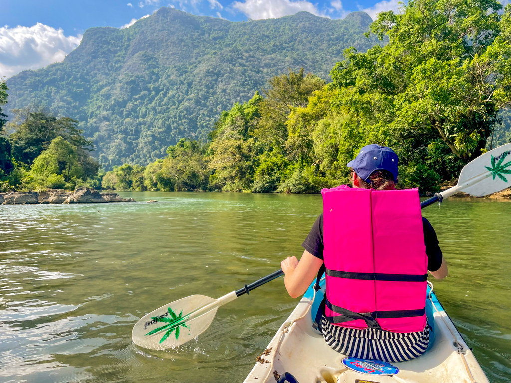 Kanotocht op een rivier tussen groene bergen tijdens 22-35ers reis Thailand, Laos & Cambodja.