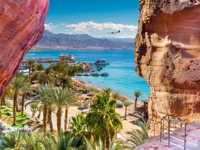 Uitzicht op strand en jachthaven van Aqaba aan de Rode Zee, gezien tussen rotswanden tijdens Route Jordanië.
