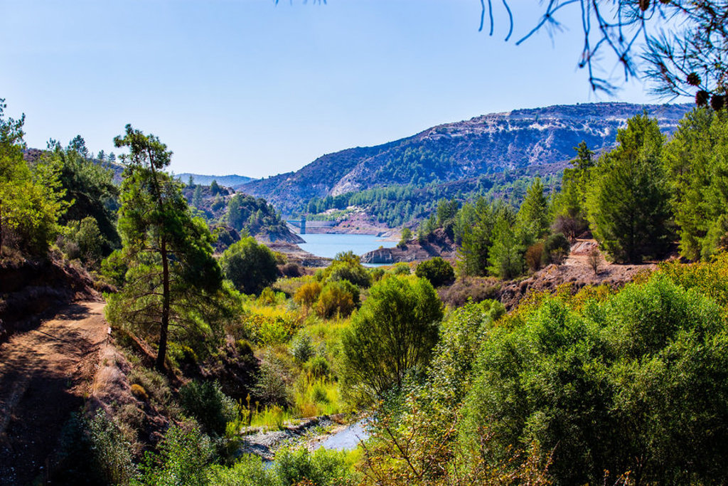 Wandelpad door groen dal met stuwmeer en bergen op Cyprus tijdens een wandelvakantie.