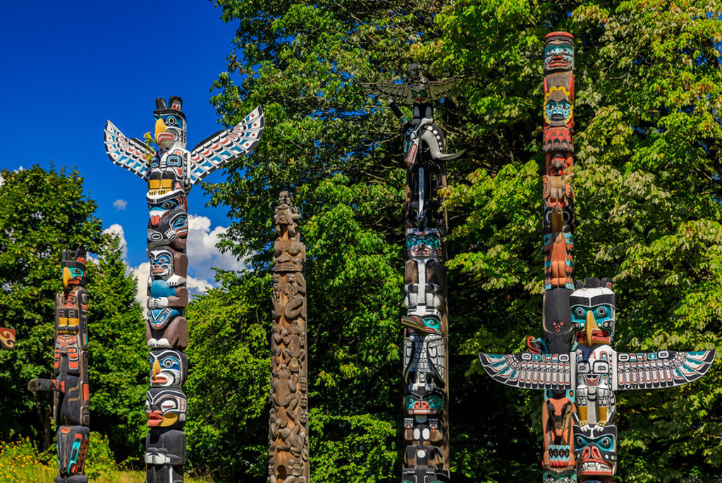 Kleurrijke totempalen in een groen park in Canada West tijdens een familiereis.