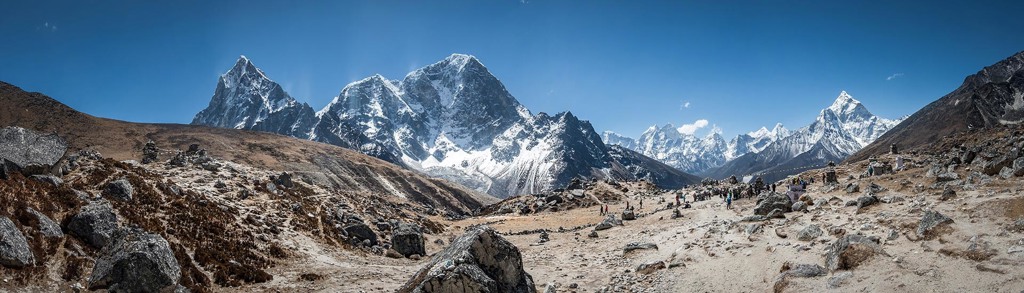 Panorama van de Everest-regio in Nepal met besneeuwde bergtoppen en wandelaars tijdens een groepsrondreis.