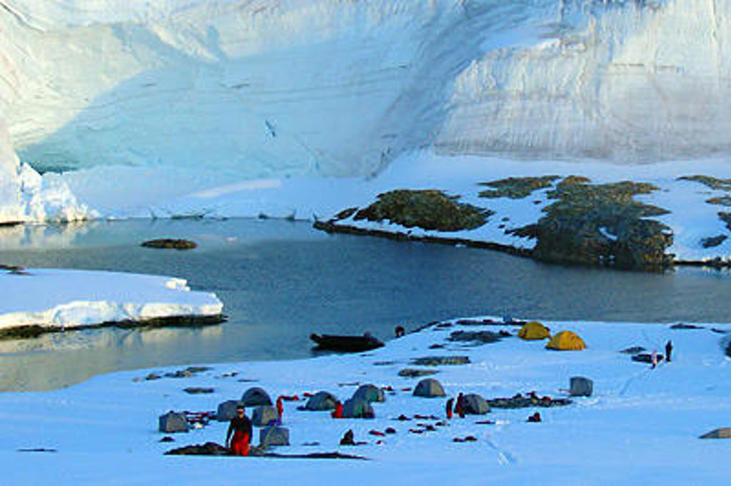 Kampeerplek met tenten aan een ijzige baai in Antarctica, tijdens de expeditie Crossing the Circle voorbij de Zuidpoolcirkel.
