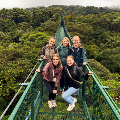 Vijf reizigers op een hangbrug boven het nevelwoud tijdens een 22-35ers reis Costa Rica.