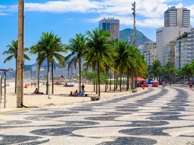Boulevard met golvend mozaïek en palmbomen langs Copacabana in Rio de Janeiro.