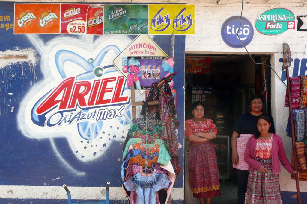 Winkel aan de Pan-American Highway in Guatemala met vrouwen in kleurrijke klederdracht bij de ingang.