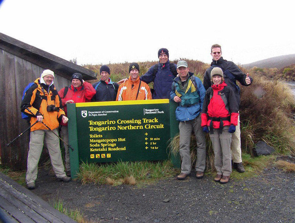 Groepsrondreis Nieuw-Zeeland: wandelaars bij het bord van de Tongariro Crossing in Tongariro National Park.