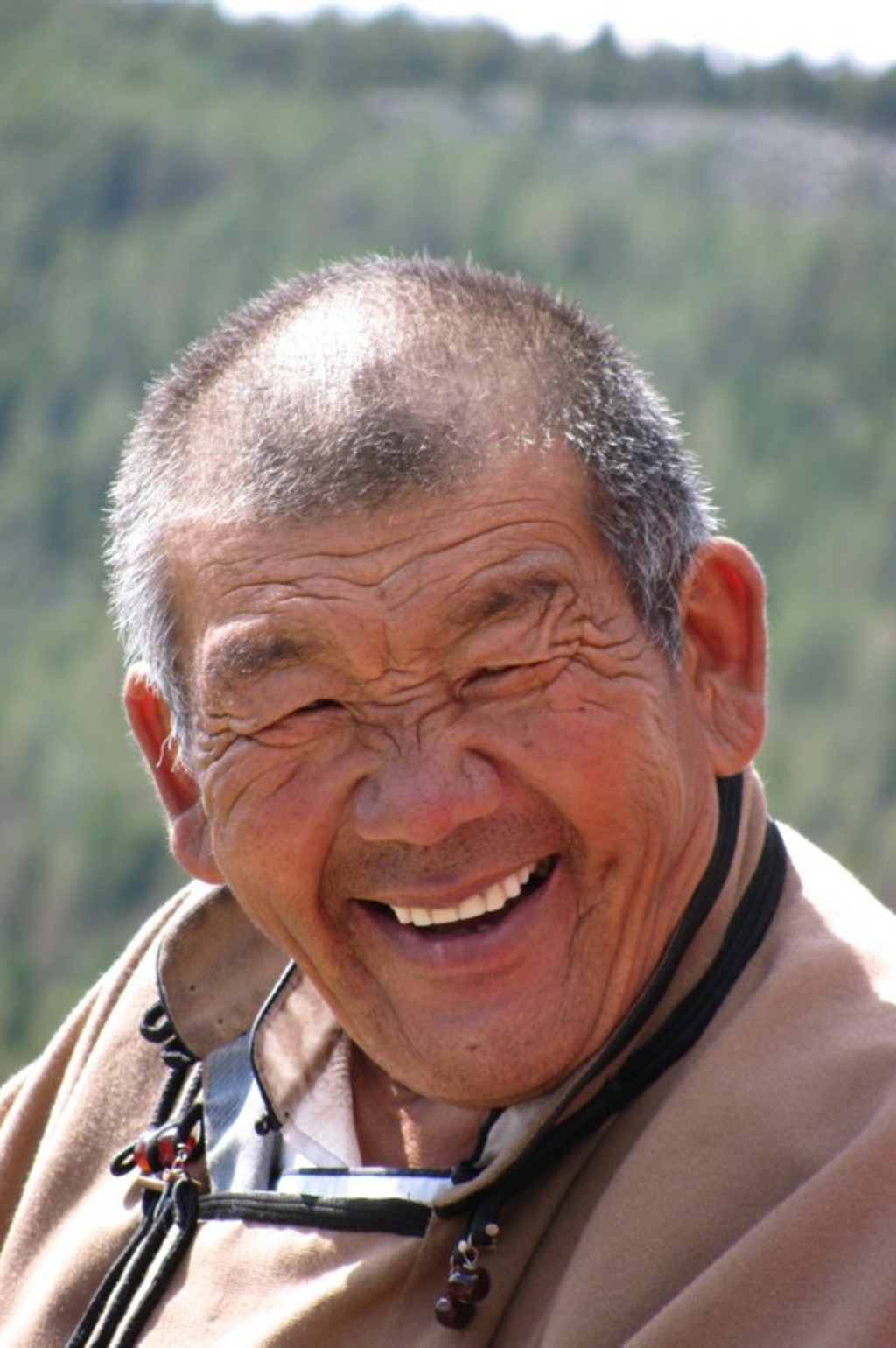 Portret van een lachende man tijdens een groepsrondreis in Mongolië.