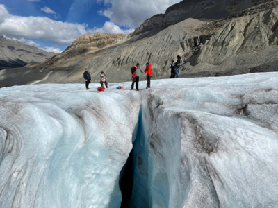 Wandelaars op een gletsjer met diepe ijsspleet, tijdens de Route Canada reis door de Rocky Mountains.