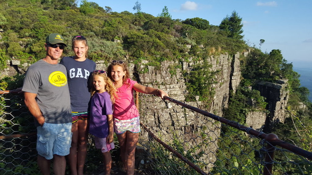 Gezin bij uitkijkpunt met uitzicht op groene kliffen tijdens familiereis Zuid-Afrika en eSwatini.