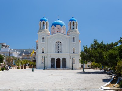 Witte orthodoxe kerk met blauwe koepels op Evia, Griekenland.