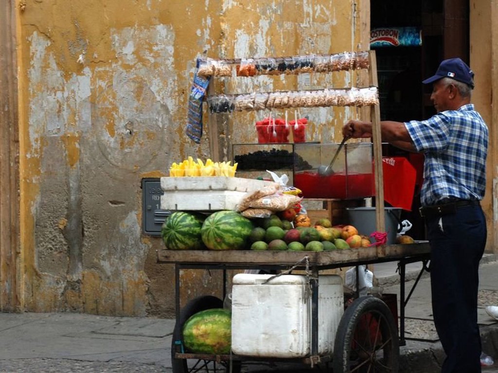 Straatverkoper met fruitkar en vers sap in Colombia tijdens een groepsrondreis.