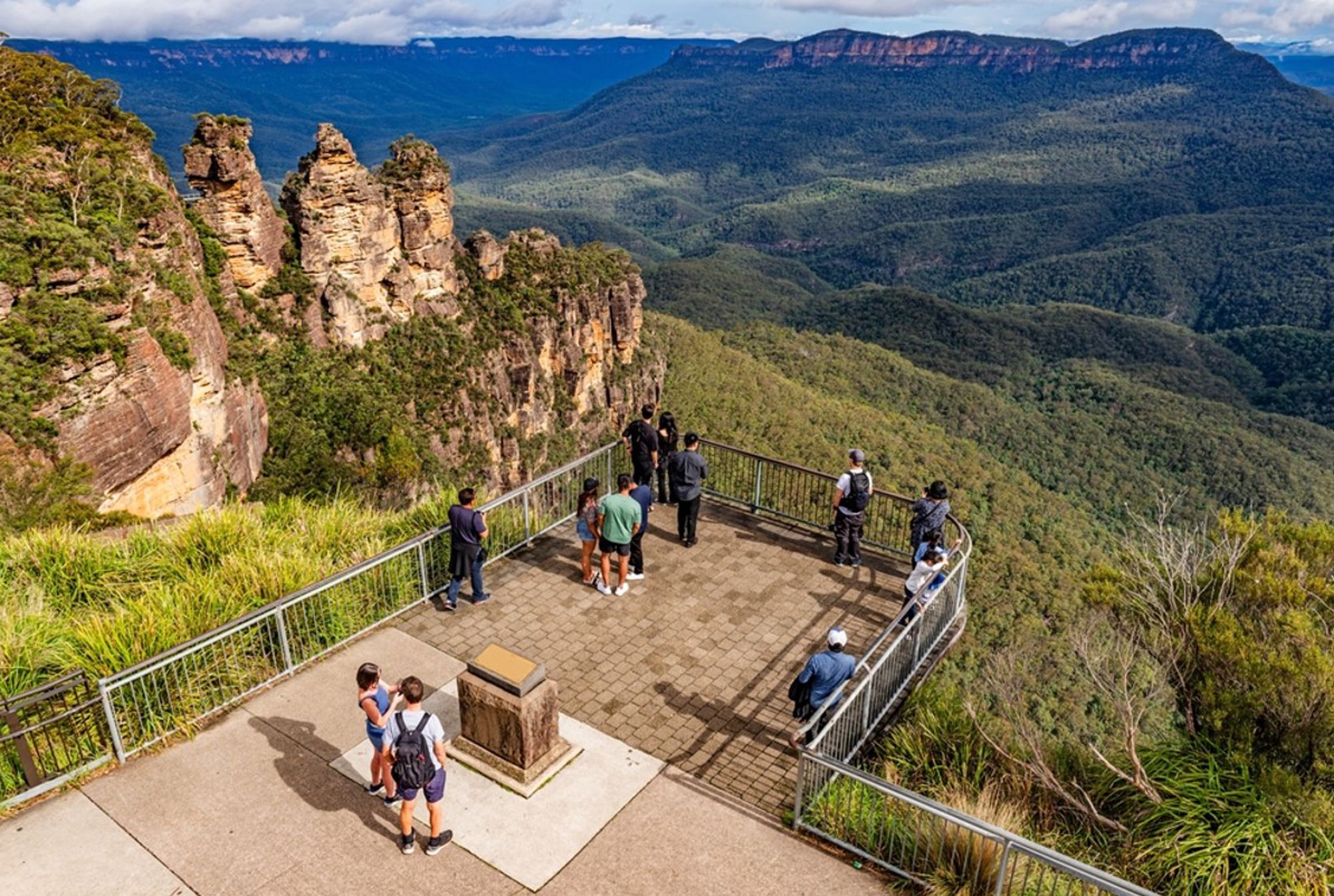 Uitzichtpunt bij de Three Sisters in de Blue Mountains, Australië, met bezoekers en uitzicht over groene valleien.