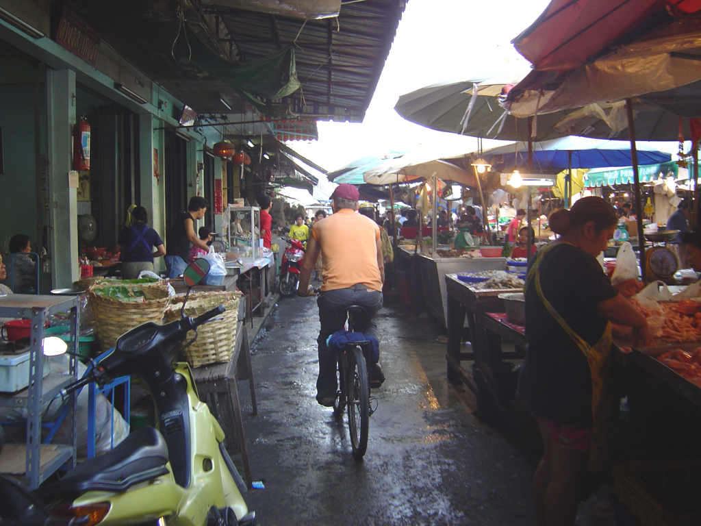 Fietser in een drukke marktstraat in Thailand tijdens een groepsrondreis.
