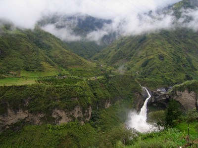 Groene Andesvallei in Ecuador met waterval en laaghangende wolken.