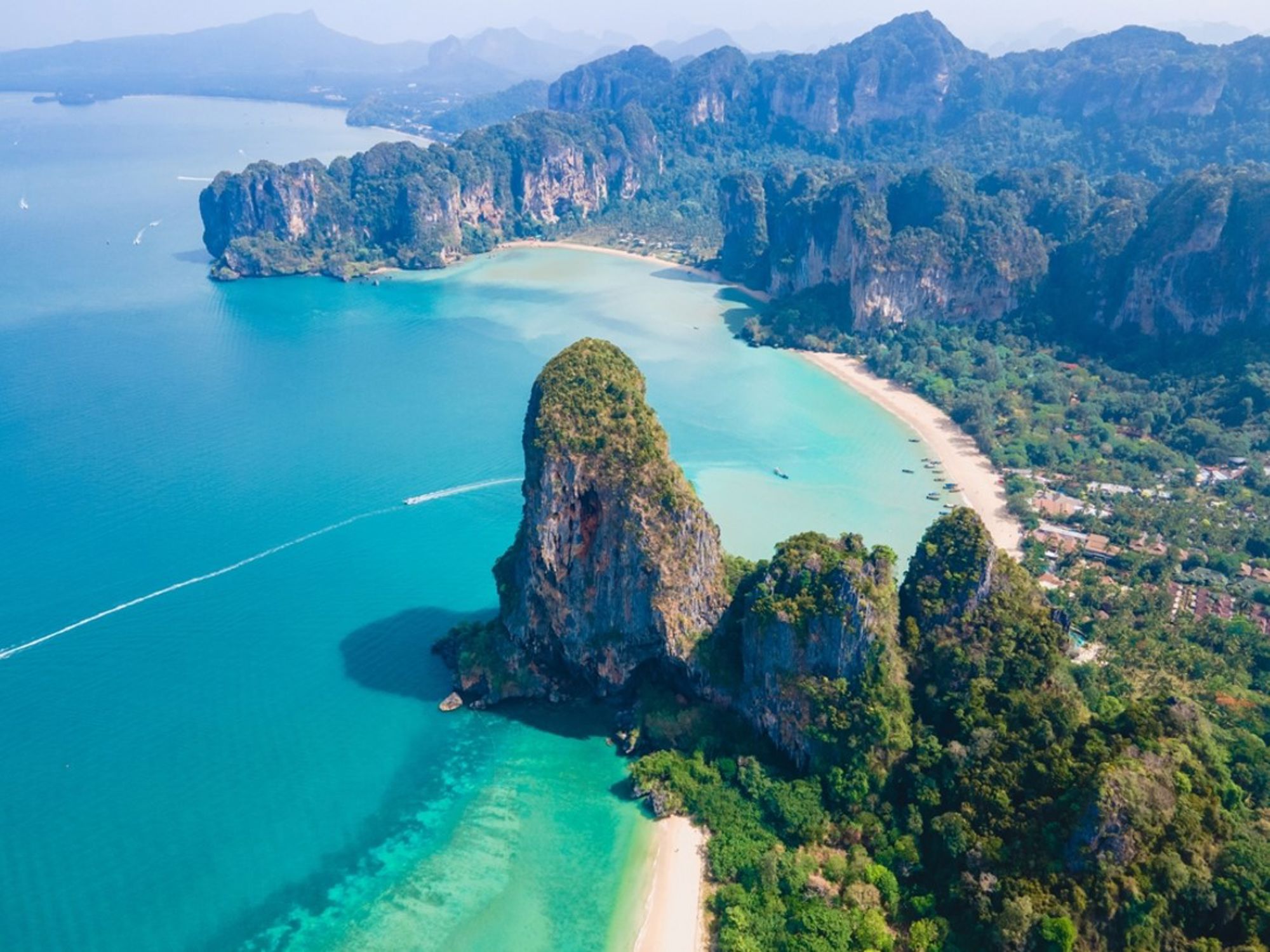 Railay Beach bij Krabi, Thailand, met kalkstenen rotsen, jungle en turkooisblauwe zee.
