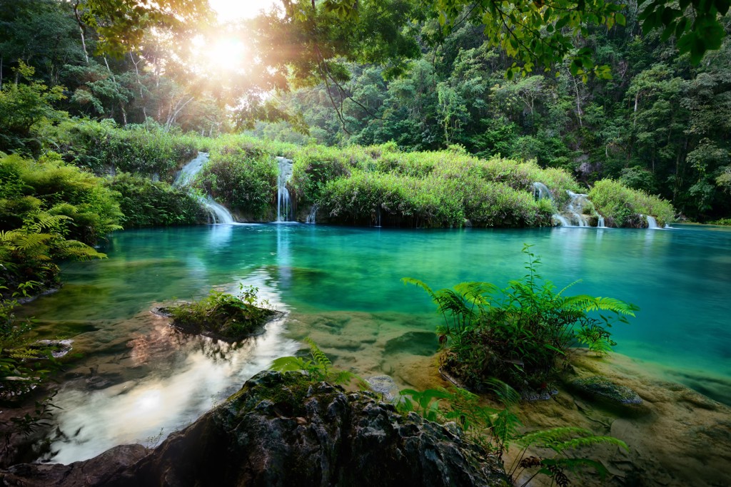 Turquoise waterval en natuurlijke zwempoel in de jungle van Guatemala, tijdens familiereis Guatemala en Belize.