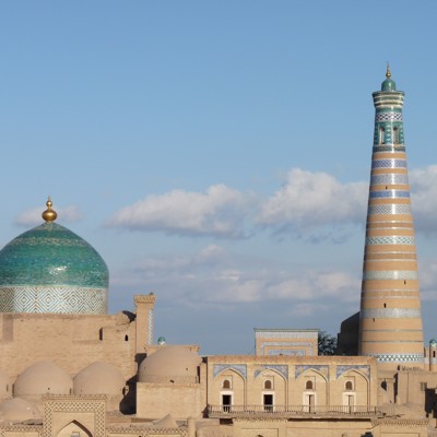 Moskee met turquoise koepel en hoge minaret in Khiva, Oezbekistan, tijdens de Groepsrondreis Zijderoute.