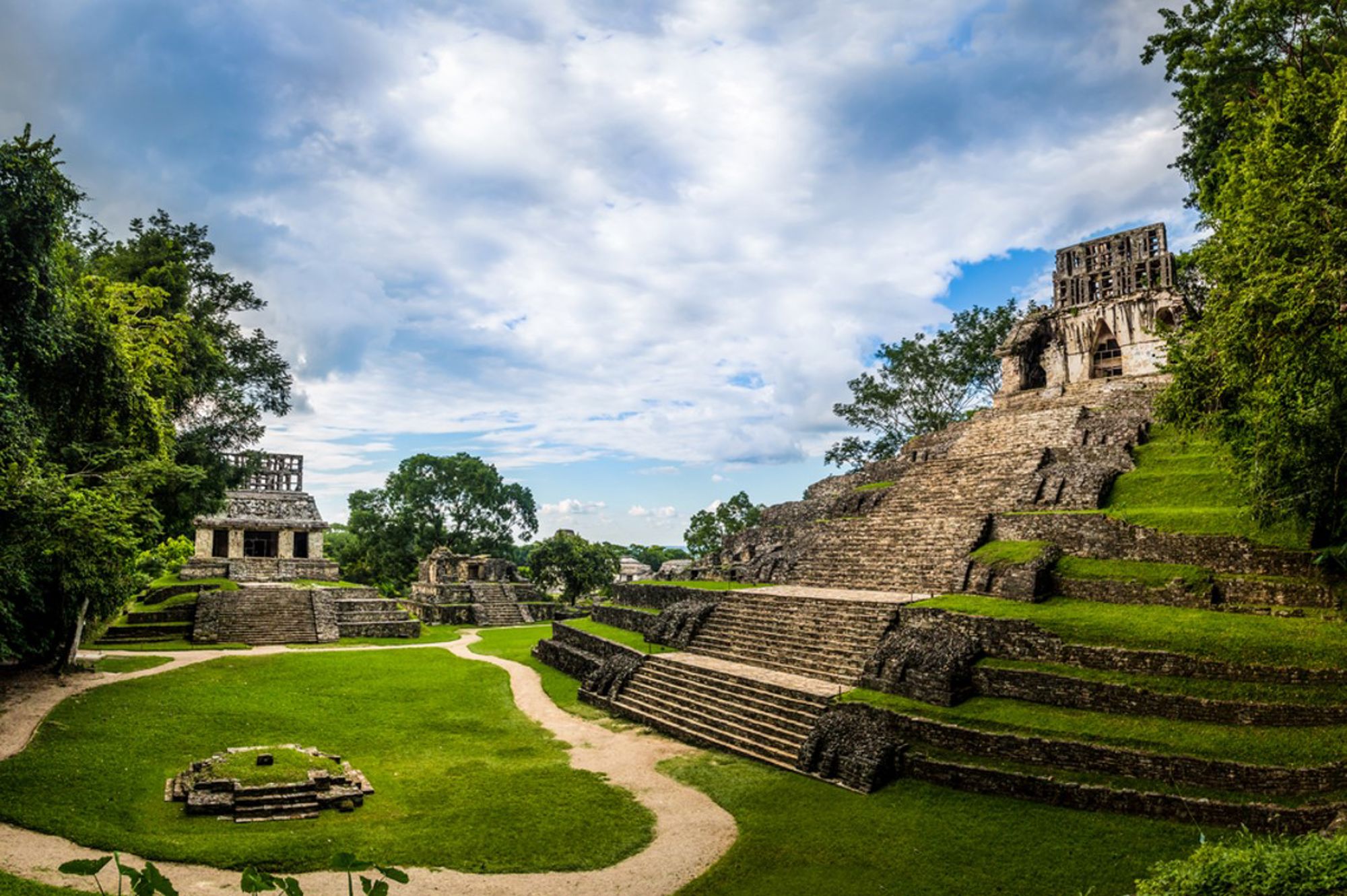 Maya-ruïnes van Palenque in Chiapas, Mexico, met stenen tempels en trappen tussen groen en jungle.