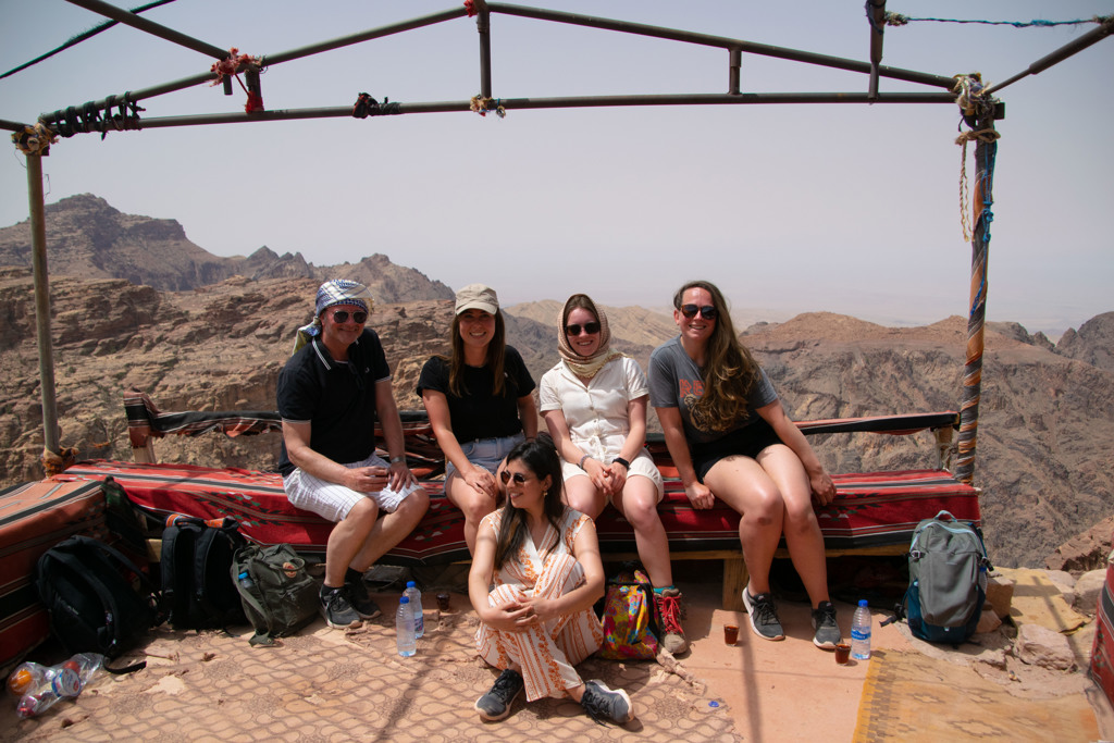 Groepsfoto van 22-35ers reis Jordanië met reizigers op een uitkijkpunt boven een berglandschap.