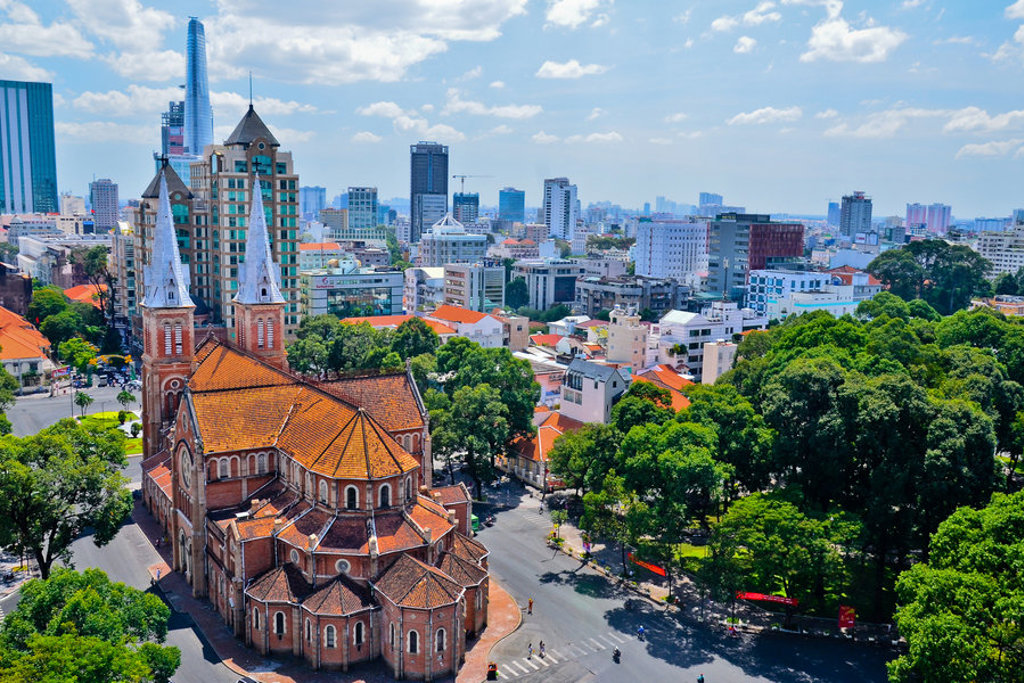 Notre-Dame-kathedraal in Ho Chi Minhstad met skyline op de achtergrond, tijdens een 22-35ers reis Vietnam.