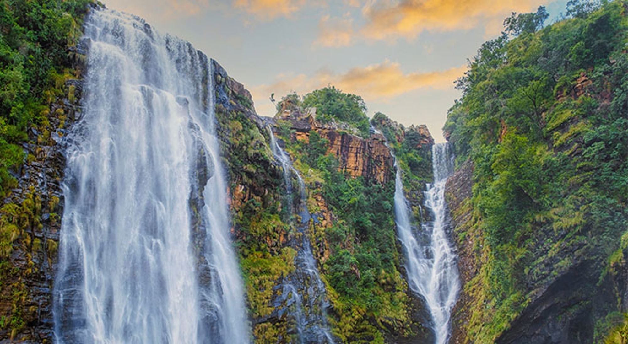 Tugela Falls waterval in de Drakensbergen, Zuid-Afrika, met groene kliffen en een heldere lucht.