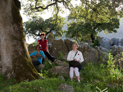 Wandelaars rusten onder een kurkeik tijdens de wandeling in Sierra de Grazalema, Andalusië.